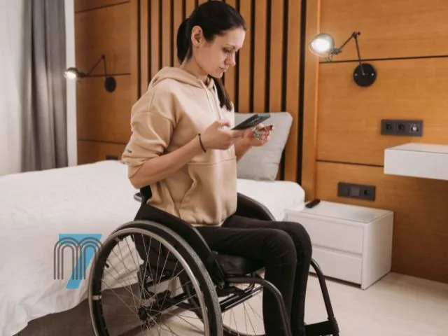 Woman in Wheelchair Using Smartphone at Home