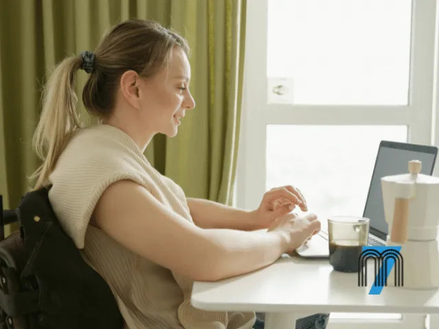 Woman Using a Wheelchair While Working on a Laptop